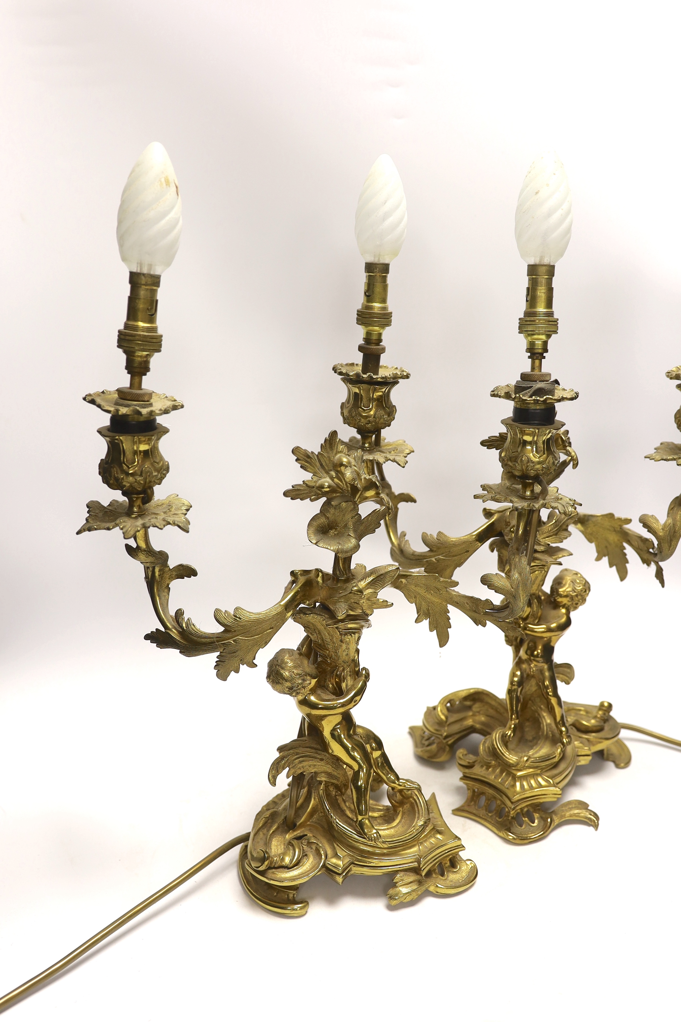 A pair of Victorian ormolu two branch candelabra, mounted as lamps, 48cm total including bulbs